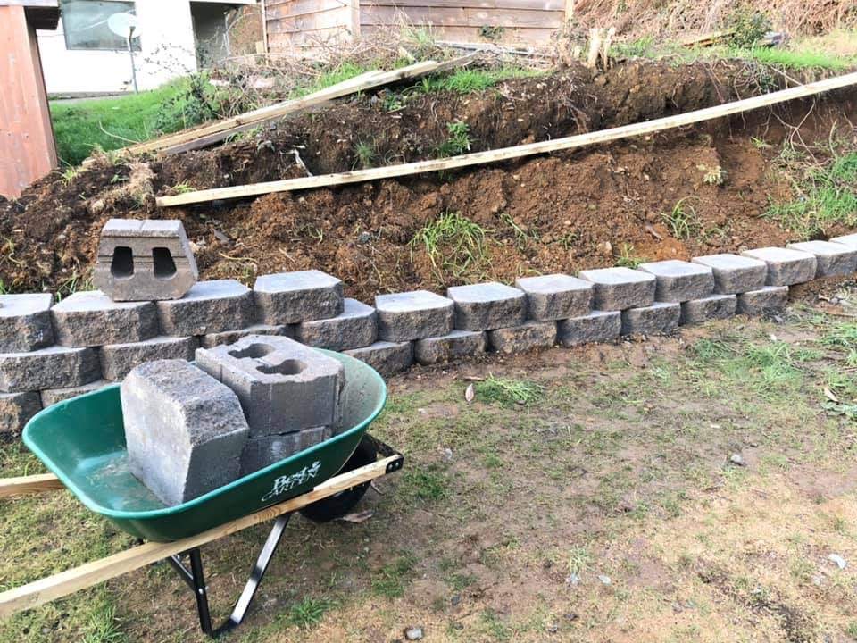 A segmental block retaining wall under construction by Carrillo's Yard Work